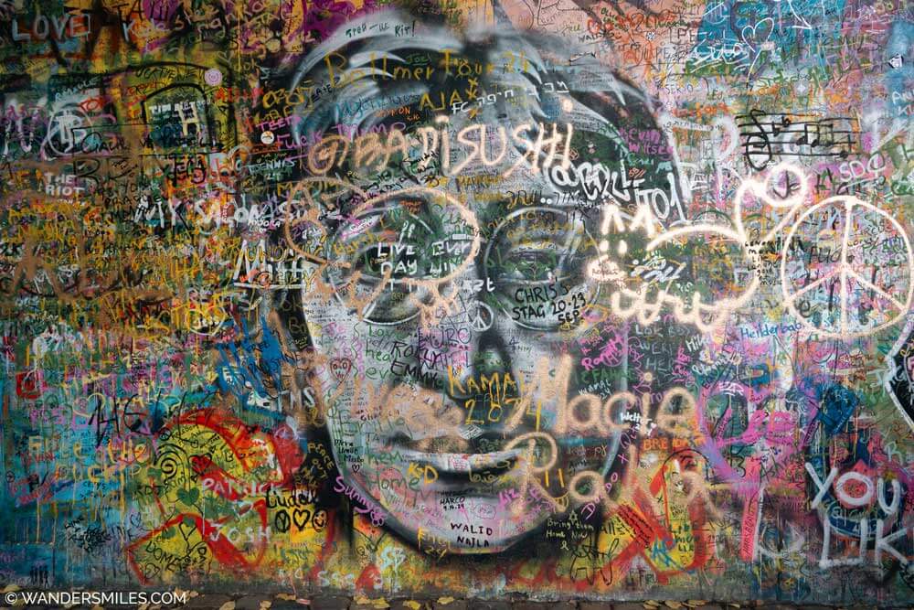 Photo of a graffiti wall with a spray painted image of John Lennon called the John Lennon Wall in Prague