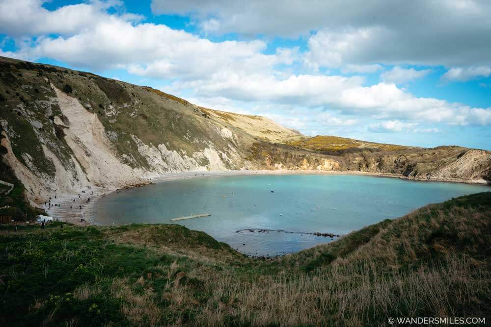 Lulworth Cove on the Jurassic Coast, Dorset: Circular cove with rock cliffs around the edge and turquoise blue water in the middle.