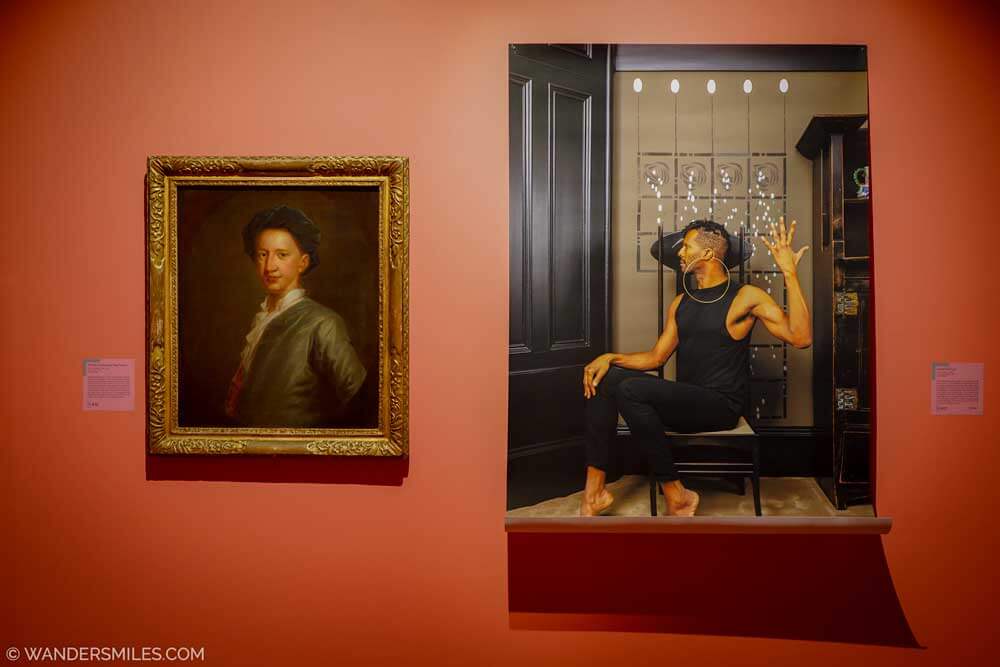Photo of art exhibits on a red wall in the Hunterian Art Gallery, Glasgow