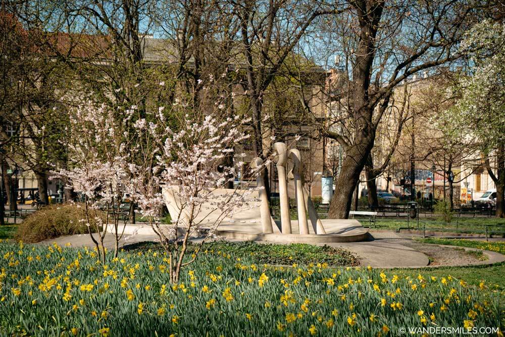 Spring in Krakow: Chopin's Piano Water Fountain in Planty surrounded by blossom and daffodils