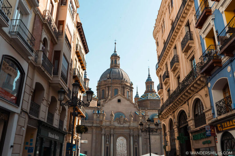 Photo of Cathdedral-Basilica of Our Lady of the Pillar in Zaragoza, also known as Cathedral-Basilica of Nuestra Señora del Pilar. Photo taken from Calle Pillar with 19th-century buildings and the cathedral at the end.