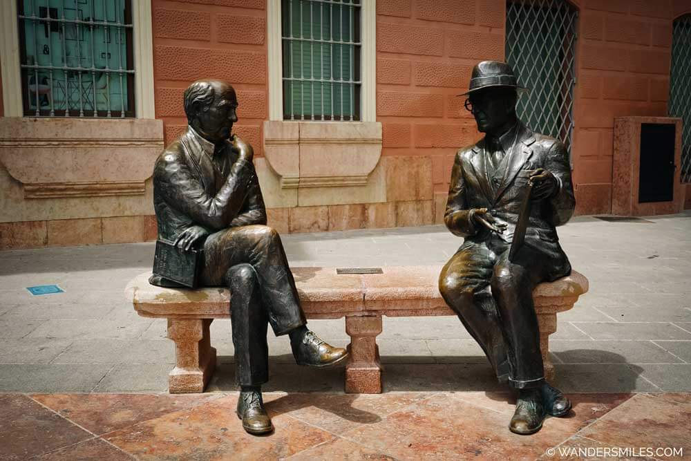 "Art without time" statue in Plaza de San Sebasti&aacute;n, Antequera. Two bronze figures (Jos&eacute; Antonio Mu&ntilde;oz Rojas and Jos&eacute; Mar&iacute;a Fern&aacute;ndez) sat on a bench.