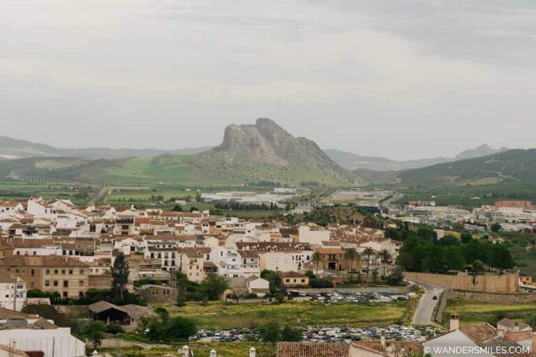 View from the Mirador de las Almenillas shows Antequera's white buildings with Lovers Rock in the distance. This looks like a face laying down. Feature photo for the blog "Unmissable things to do in antequera"