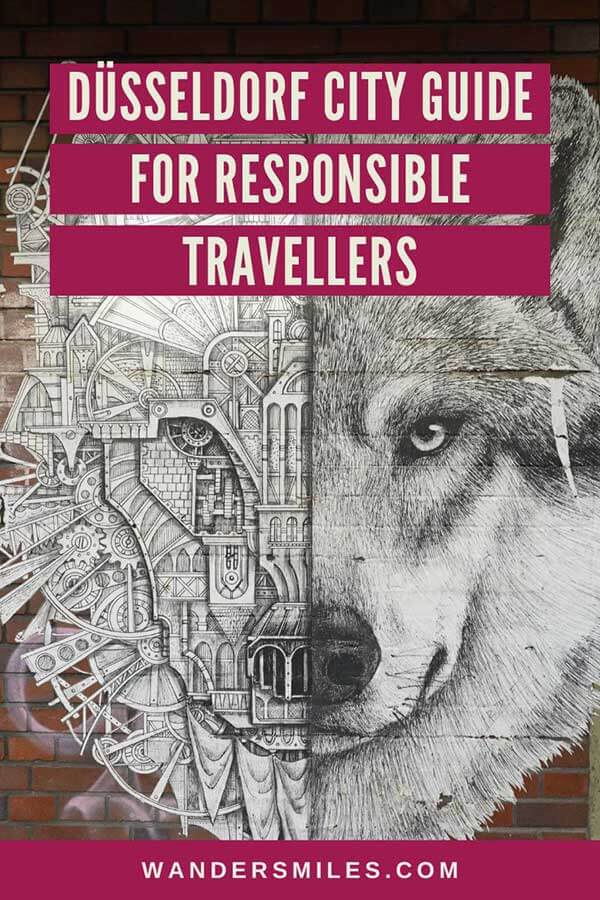 Photo of a wolf's face mural on a wall in Bilk Dusseldorf. Text overlaid "Best Düsseldorf City Guide For Responsible Travellers"