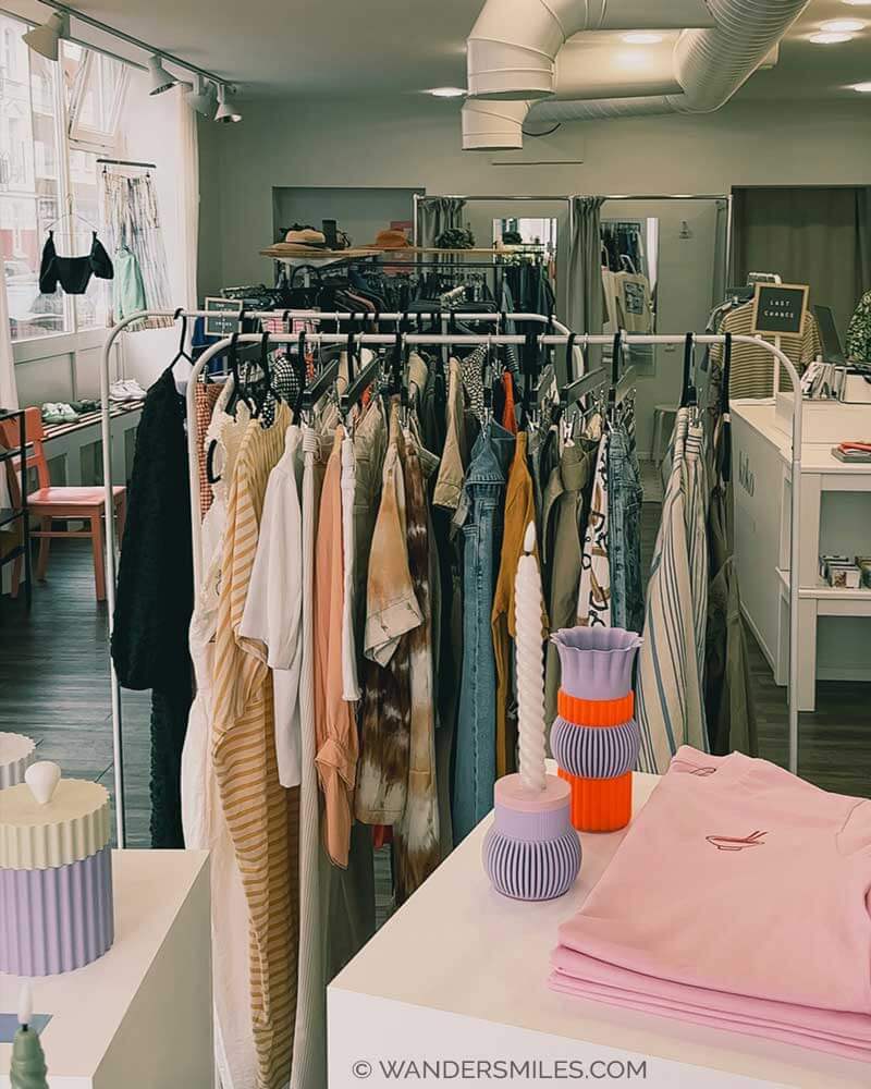 Photo of a vintage concept store called KOKO Selected in Dusseldorf. Rails of second hand clothing, tables with fair fashion and artisan products.