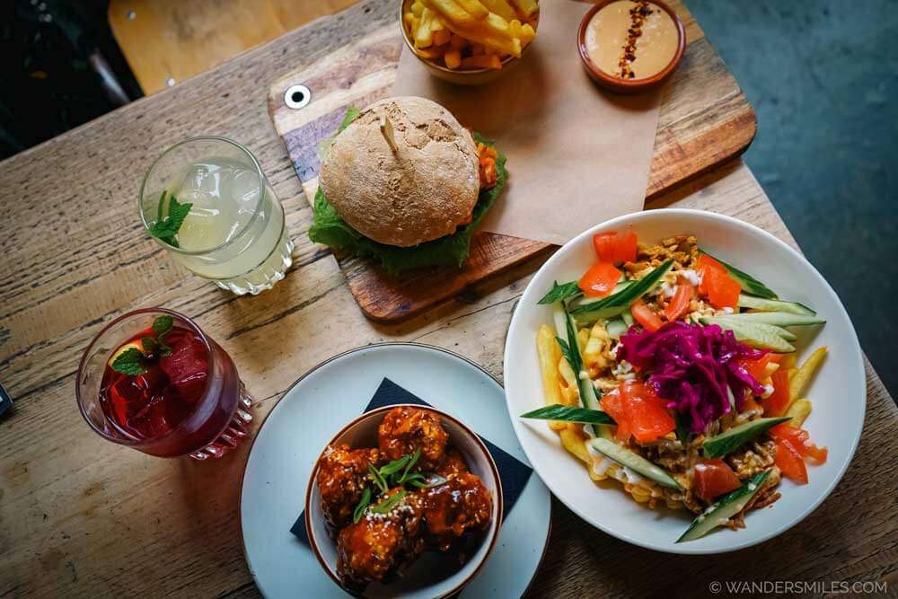 Aerial photo of colourful plant-based dishes on a wooden table in the Backyard &mdash; one of the most sustainable restaurants in Rotterdam Netherlands