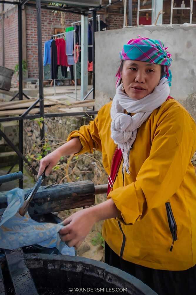 H'Mong lady putting hemp fabrics in an indigo vat for batik, located in Sapa Vietnam