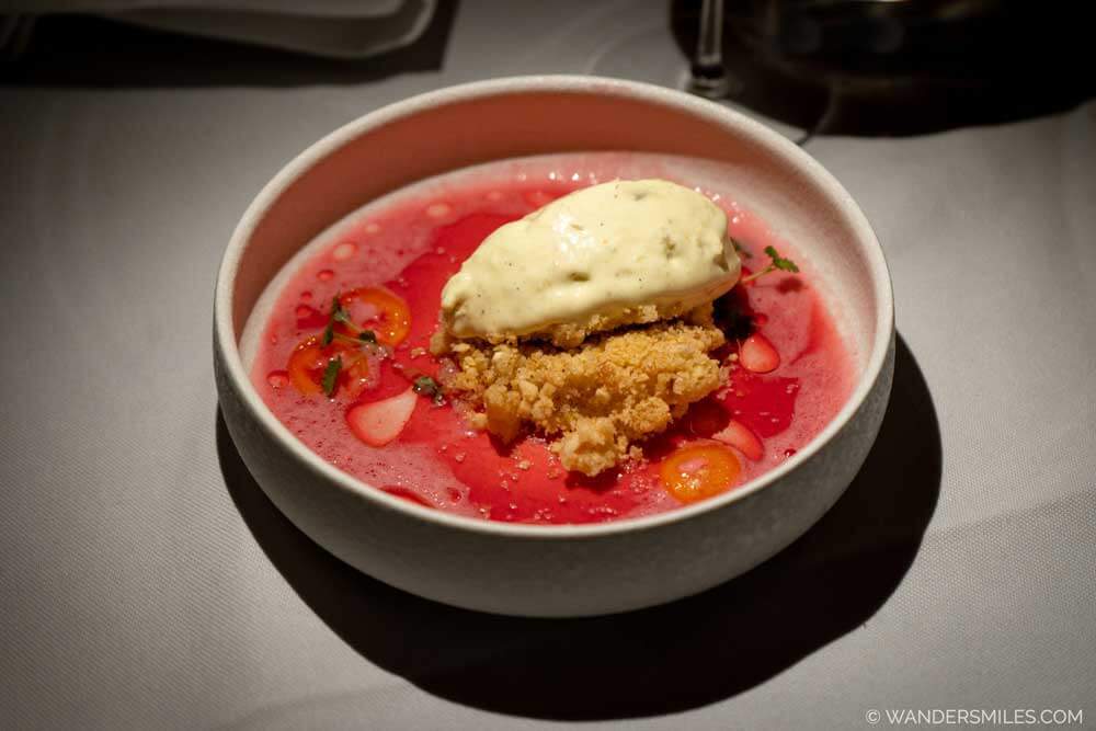 Dessert in a white bowl in Kasvio restaurant in Utrecht &ndash; Citrus and raisin ice cream, sea buckthorn mousse, almond crumble, citrus sauce, and kumquat