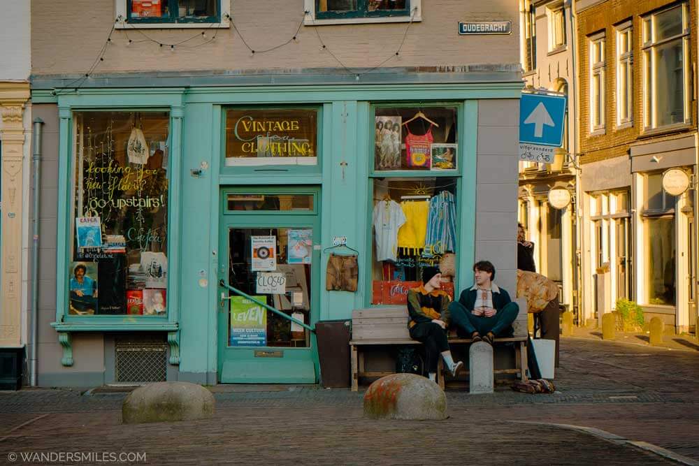 Two men sitting outside a vintage shop along the canal in Utrecht
