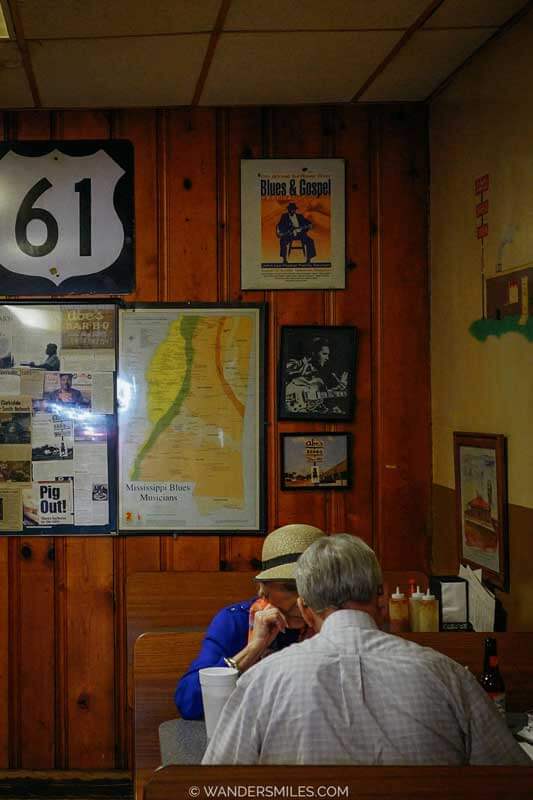 An older couple sat in a wooden booth at Abe's BBQ place at the Crossroads in Clarksdale, Mississippi