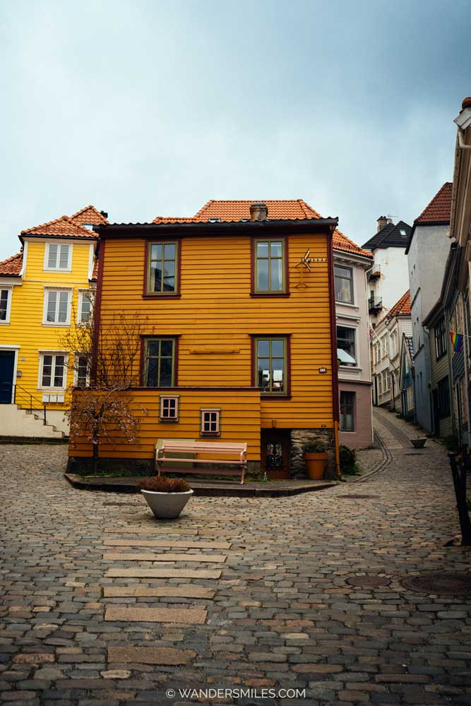 Knøsesmauet: A street in Bergen with ochre-painted house and a bench