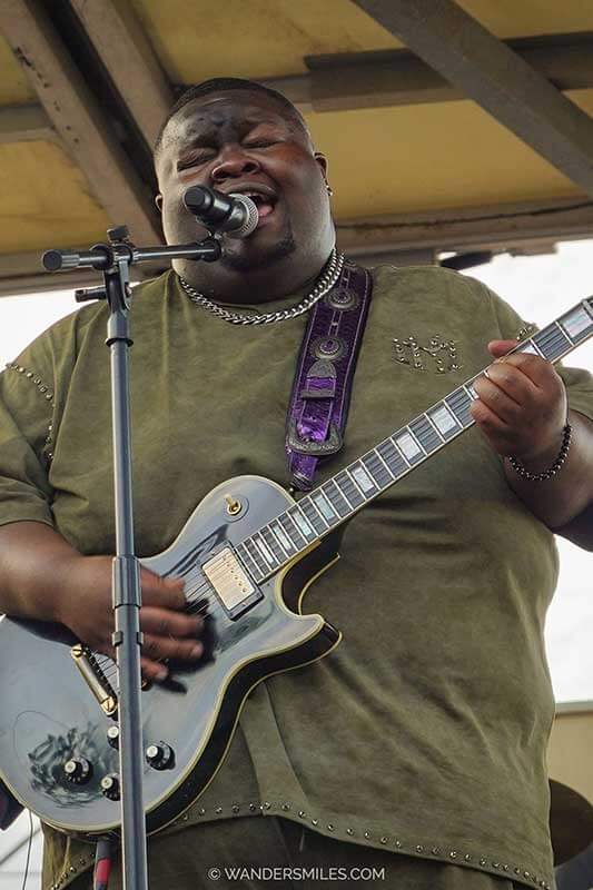 Kingfish performing at Juke Joint Festival 2026: A large black man singing blues and playing guitar on the stage