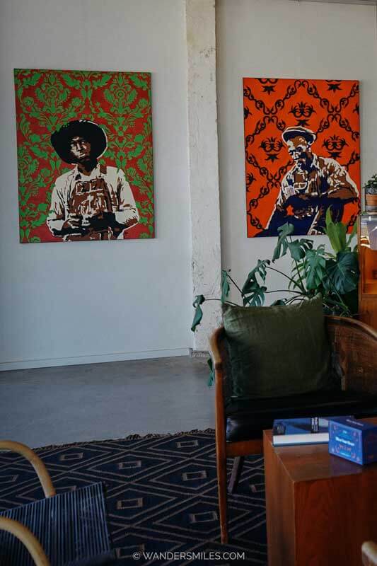 The communal area of Travellers Hotel, Clarksdale, with chairs, plants and blues-inspired paintings by local artists
