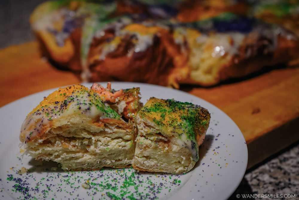Colourful King Cake for Mardi Gras, with icing, sprinkles (purple, green & gold), and a plastic baby
