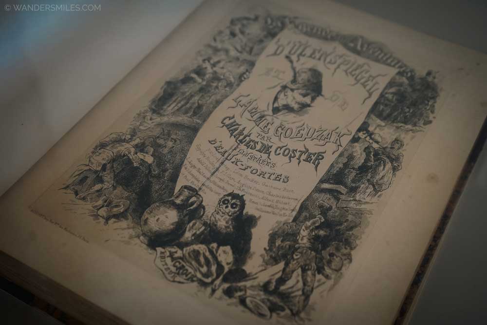Black and white illustration of Tijl Uilenspiegel and other characters in Charles de Costa's book, on display in the Tijl Uilenspiegel Museum, Damme, Belgium.