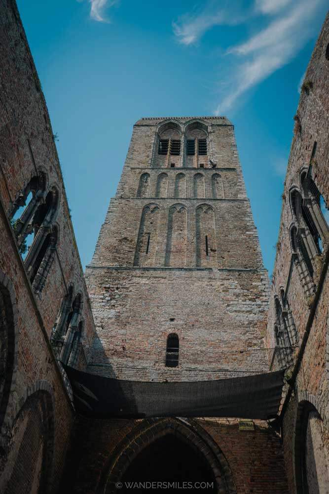 The brick tower of Church of Our Lady in Damme, with blue skies