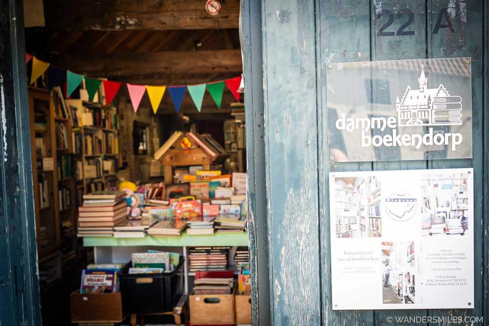 Door with "Damme Boekendorp" (Damme Bookshop) sign, and inside shelves of books