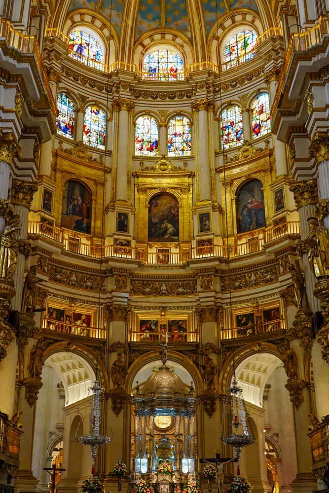 Opulent and golden Capilla Mayor with stained glass and dome at Granada Cathedral, Spain